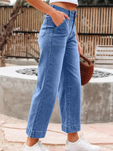 High-waisted blue denim wide leg flare jeans with a relaxed fit and rolled cuffs for casual wear