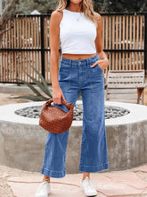Brown woven leather handbag with structured rounded shape and braided handles paired with high waisted flare jeans