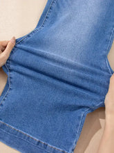 A pair of medium-wash blue denim high-waisted wide leg flare jeans with visible stitching and relaxed fit