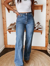 High-waisted wide leg blue denim jeans with a five-pocket design and button closure