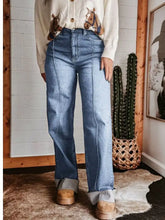 High-waisted wide leg jeans in blue denim fabric blend with straight-leg cut and frayed cuffs