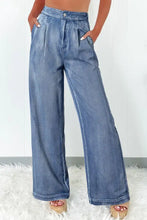High-waisted wide-leg jeans in medium blue denim with pleated front and button closure for stylish comfort