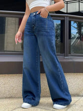 High-waisted wide leg jeans in medium blue denim with visible stitching and button fly closure