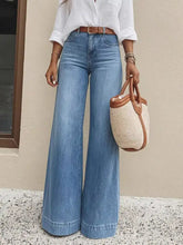 Light-wash blue denim high-waisted wide leg jeans with a classic waistband and brown leather belt