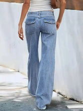 Back side of light-wash denim high-waisted wide leg jeans with frayed hems and functional back pockets