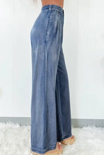 High-waisted wide-leg jeans in faded blue denim with a relaxed flowing silhouette for casual wear