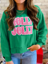 Green holly jolly sweatshirt with pink embroidered lettering and white trim, slightly stretchy and machine wash care instructions