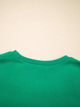 A vibrant green holly jolly towel embroidered christmas holiday sweatshirt with ribbed collar, machine wash care instructions