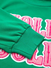 Green holly jolly towel embroidered Christmas holiday sweatshirt with bold pink and white lettering, slightly stretchy, machine wash care instructions