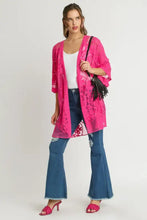 Woman in hot pink floral lace kimono waist tie cover-up with ripped jeans