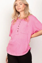 Woman in hot pink henley shirt with half button and twisted sleeve band