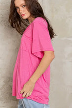 Model in hot pink loose fit V-neck T-shirt with chest pocket in knit slub fabric