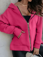 Hot pink zip-up slit hoodie with asymmetrical zipper, pockets, and long sleeves