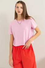 Woman in Hyfve Round Neck Cropped T-Shirt with red wide-leg pants