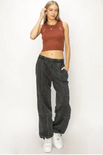 Woman models HYFVE stitched design drawstring sweatpants in rust crop top