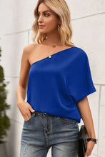 Woman in Ivy Lane single shoulder half sleeve T-shirt with jeans and clutch