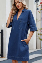 A women’s denim dress with a johnny collar, half sleeves, and two front pockets in classic blue denim