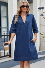 A navy blue denim dress with johnny collar, two front pockets, and half sleeves for casual wear