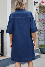 A navy blue denim dress with johnny collar and half sleeves crafted from sturdy denim fabric