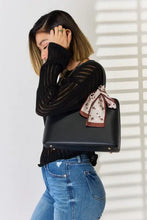 Woman in black top and jeans models David Jones PU leather handbag