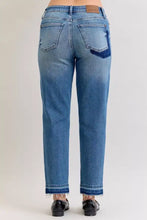 Back side of judy blue plus size mid rise blue denim jeans with faded wash frayed hems and dark blue patch on pocket