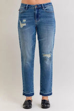 Mid-wash blue judy blue plus size mid rise denim jeans with distressed frayed patches on thighs and knees