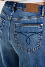 Back view of blue denim judy blue high waist palazzo jeans with brown leather brand patch and heart stitch design on pocket