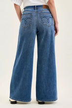 Back view of judy blue high waist palazzo jeans in blue denim with classic pockets and brown leather waistband
