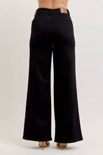 Black judy blue high-waisted wide leg jeans with a sleek silhouette and brown leather brand patch at the waistband
