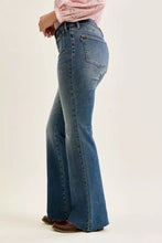 Judy Blue mid rise flare jeans in faded blue denim with high waist front flap pockets and frayed hem