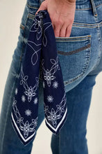 A navy blue bandana with white floral and geometric patterns on the jaqueline flare jeans bandana loop