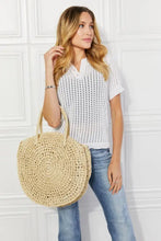 Woman in white eyelet top, blue jeans, holding Justin Taylor Beach Date Straw Rattan Handbag in Ivory