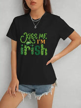 Black short-sleeve crew neck t-shirt with green Kiss Me Im Irish graphic