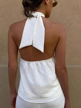 White crinkled fabric knotted halter neck cami showing the tied bow at the back of the halter neck top