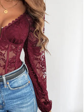 A maroon lace long sleeve bodysuit with a corset-style front combining elegance and structure