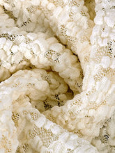 Cream-colored lace ruffle trim tie-front cami featuring textured lace fabric with delicate raised floral pattern and openwork mesh