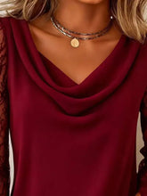 A deep red cowl neck blouse featuring sheer lace sleeves and a stylish cowl neck design