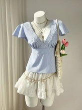 Light blue striped lace trim v-neck blouse with delicate lace detailing around the neckline and puff sleeves