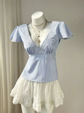 A light blue and white striped lace trim v neck blouse with puffed short sleeves and a fitted waistband