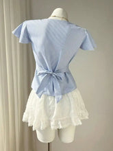 Light blue and white striped short-sleeved lace trim v-neck blouse with gathered back and fabric bow tie shown from back