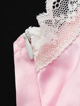 Lace trimmed satin pink cami featuring delicate white lace trim and matching zipper pull for elegant wear