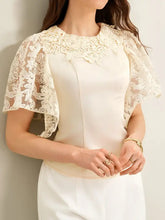 Cream-colored lace trimmed short sleeve blouse with delicate floral lace detailing on neckline and flutter sleeves