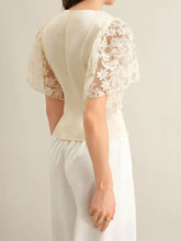 Cream-colored lace trimmed short sleeve blouse with delicate floral lace sleeves and fitted back side view