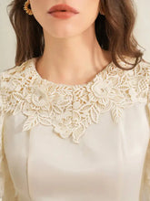 Cream-colored lace trimmed short sleeve blouse with intricate floral lace collar in soft fabric