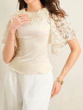Cream-colored satin lace trimmed short sleeve blouse with delicate floral lace cap sleeves for elegant wear