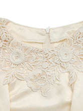 Cream-colored satin lace trimmed short sleeve blouse with intricate white floral lace detailing around the neckline