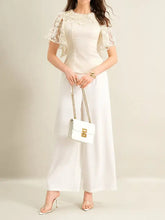 White leather crossbody bag with gold-tone chain strap and rectangular clasp paired with lace trimmed short blouse