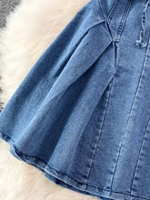 A medium-wash denim a-line mini dress with pleated detailing and a drawstring waist lace-up denim dress