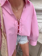A soft pink satin-like oversized shirt with a lace-up front and long sleeves perfect for stylish casual wear