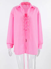 A vibrant pink oversized shirt with long sleeves lace-up front sheer fabric and relaxed fit lace-up front oversized shirt
